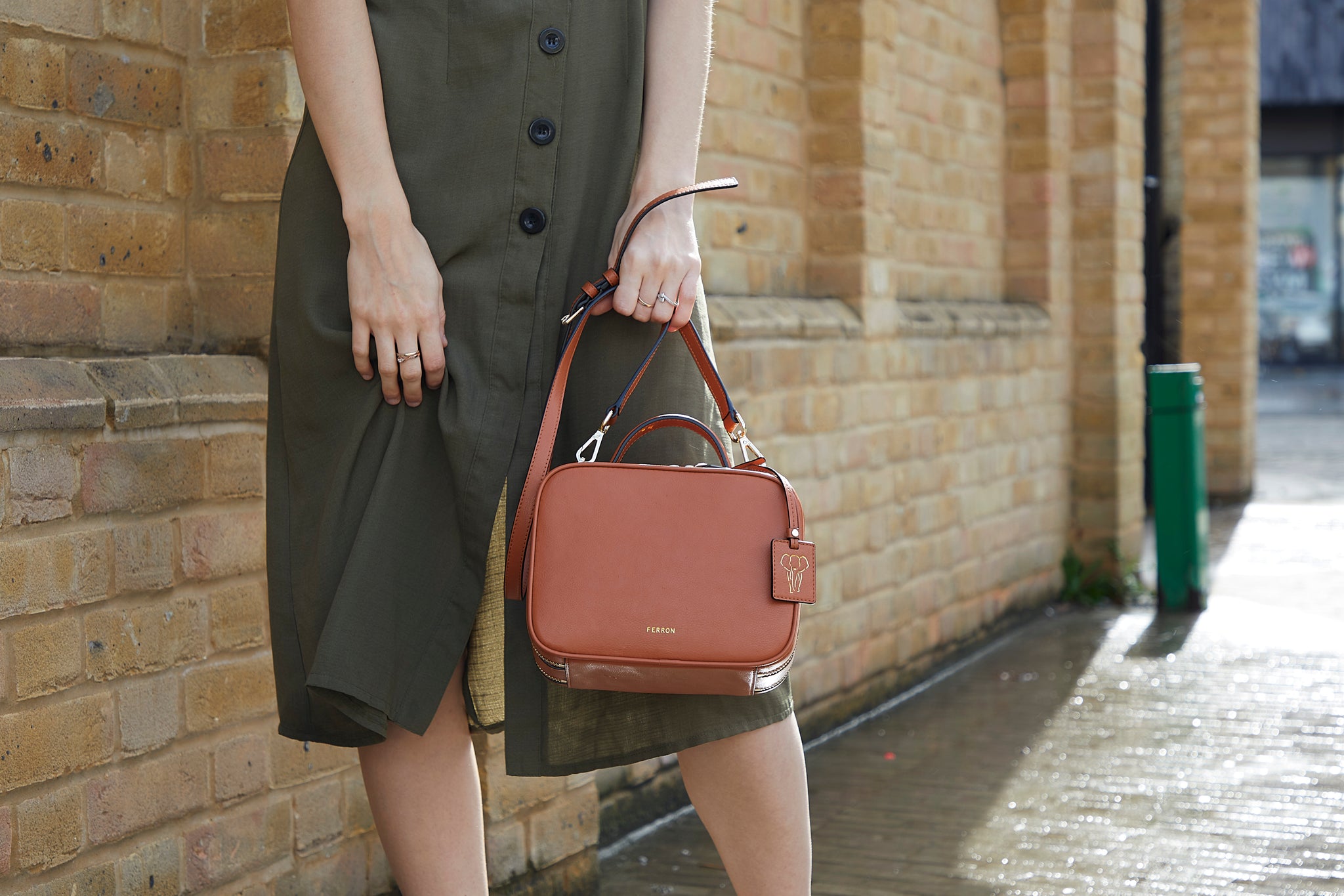 Model holding the crossbody bag by handle